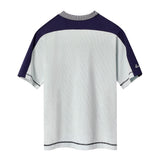Backside of light blue cotton mesh short-sleeve shirt with navy shoulder panels and a striped ribbed collar. 