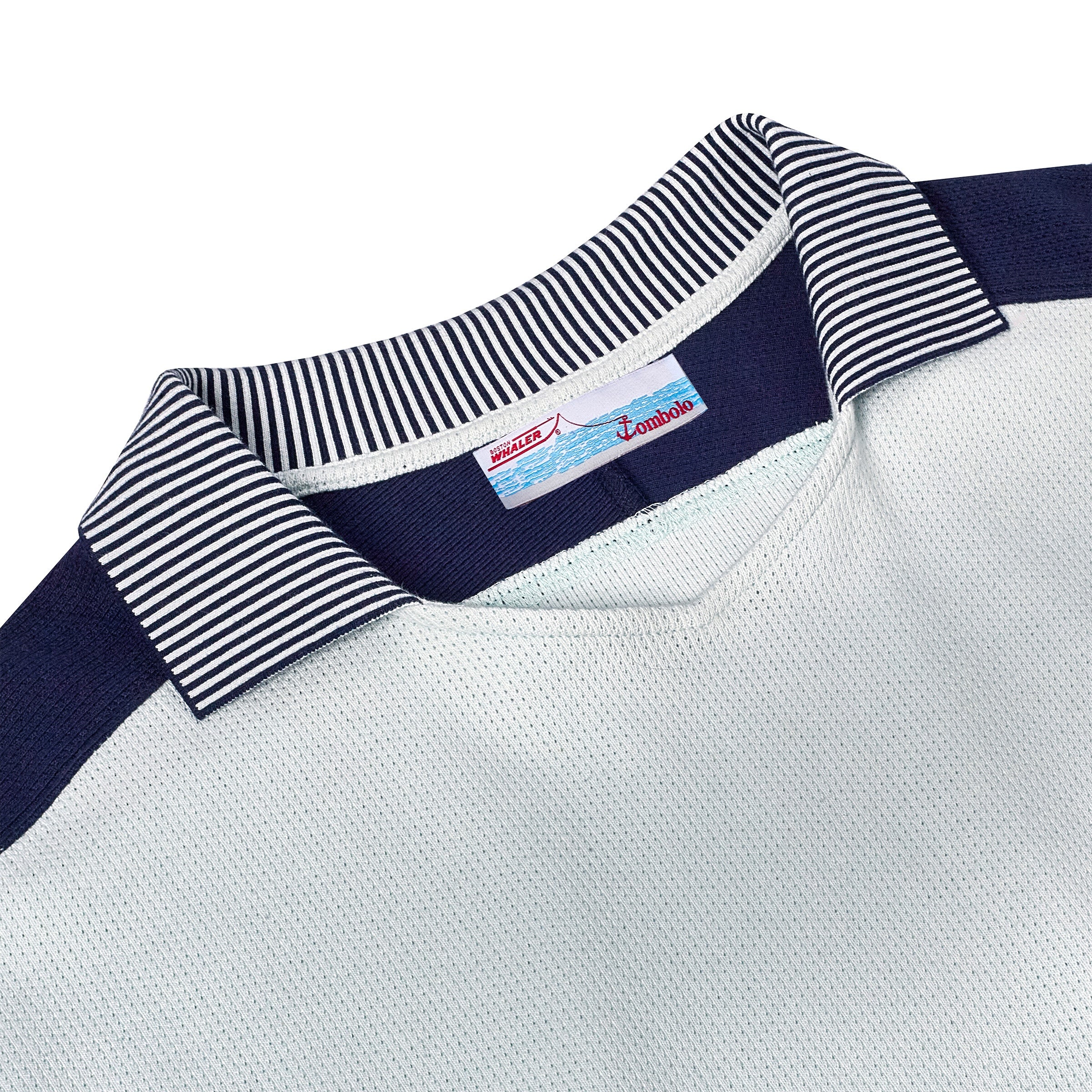 Close-up of black-and-white striped collar, with interior label featuring a Boston Whaler boat graphic above blue waves and red 'Tombolo' text.