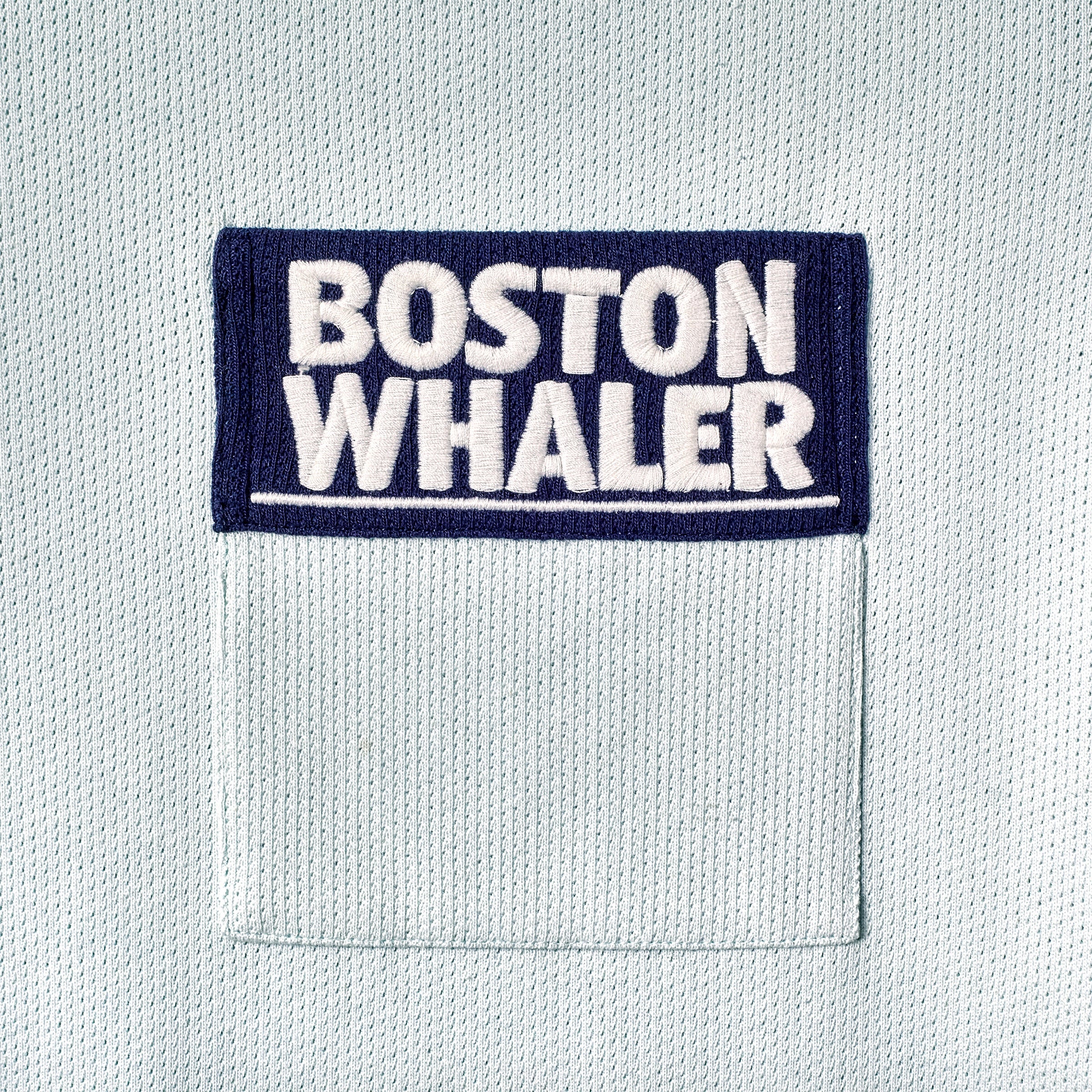 Close-up of color blocked chest pocket with embroidered 'Boston Whaler' logo.