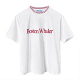 White cotton t-shirt with red embroidered text reading 'Boston Whaler' across the chest and a red-and-white embroidered neckline detail.