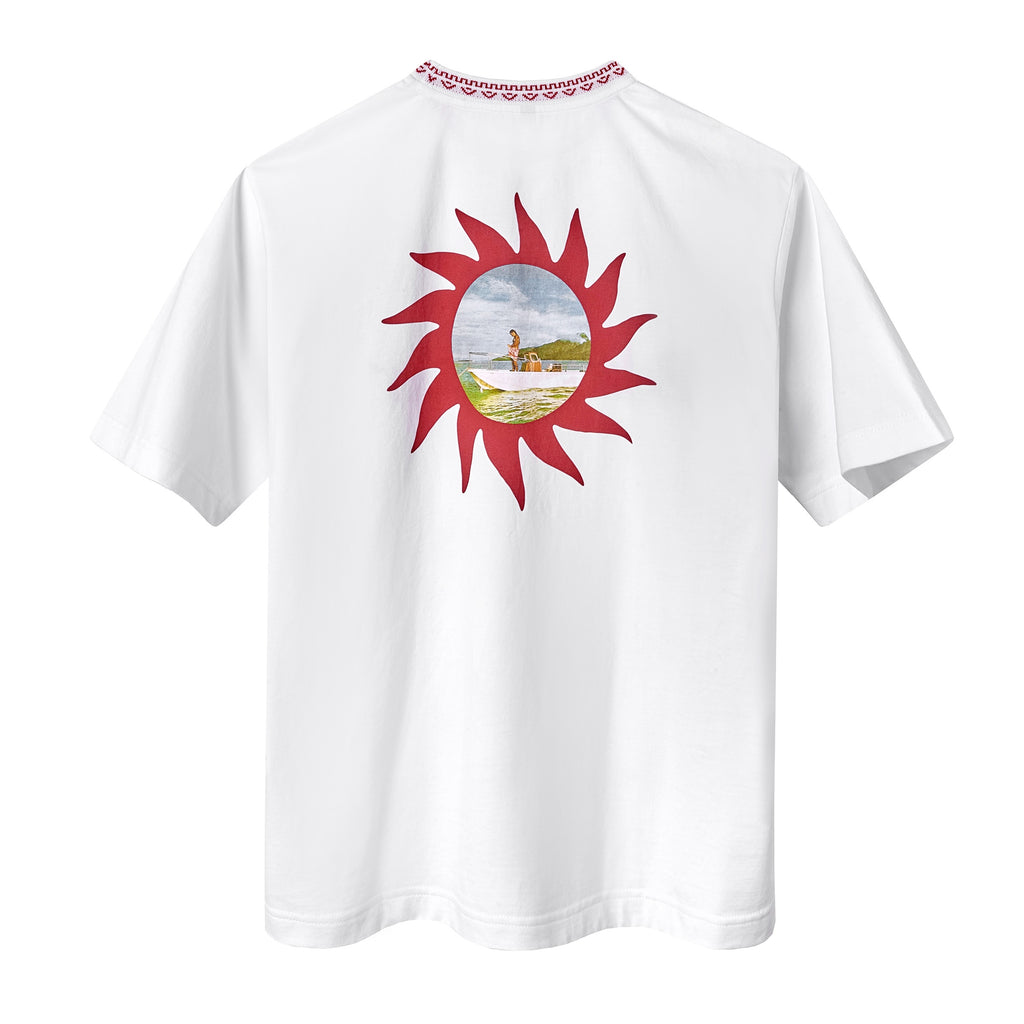 Back of a white t-shirt featuring chain-stitched sunburst artwork framing a printed vintage photo of a woman on a boat, and a ribbed neckline with red details. 