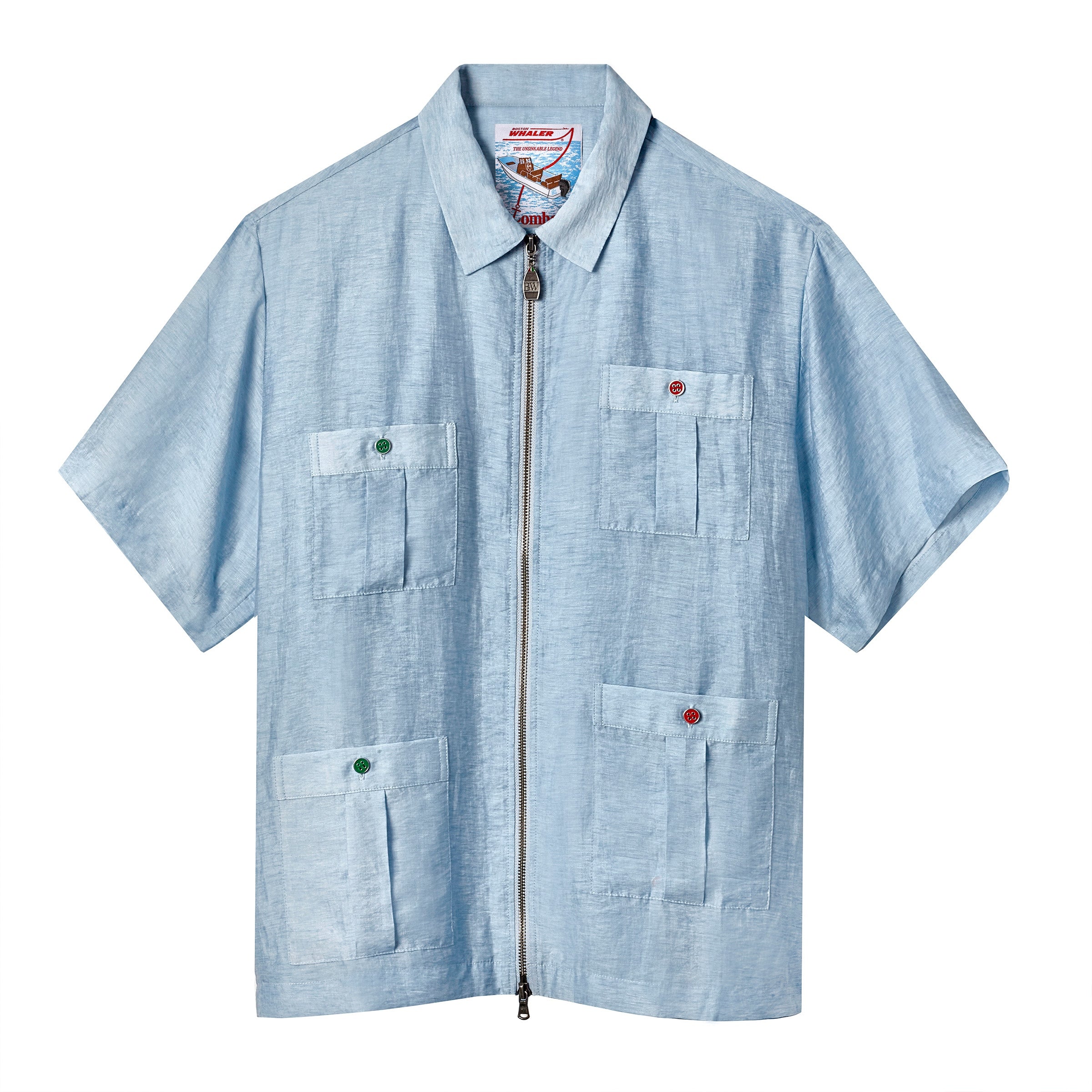 Light blue short-sleeve zip-up shirt with four front pockets, each fastened by either a red or green button. Collar detail and nautical-themed inner label visible.