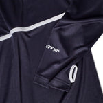 Close-up of a navy sun shirt sleeve featuring white piping, UPF 50+ text, and a white-trimmed thumbhole.