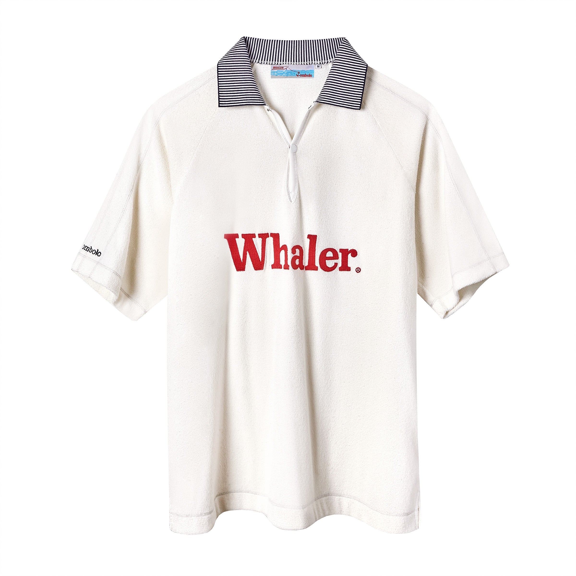 White short-sleeve terry polo with a black-and-white striped collar and a narrow ribbed placket. Red 'Whaler' text is embroidered across the chest, and a small black 'Tombolo' logo appears on the left sleeve.