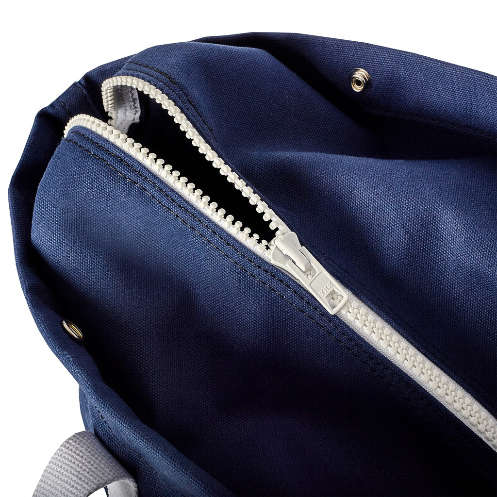 Close-up of navy canvas tote's white zipper.