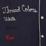 Close up of embroidery reading 'Thread Colors: White, Black, Red.'