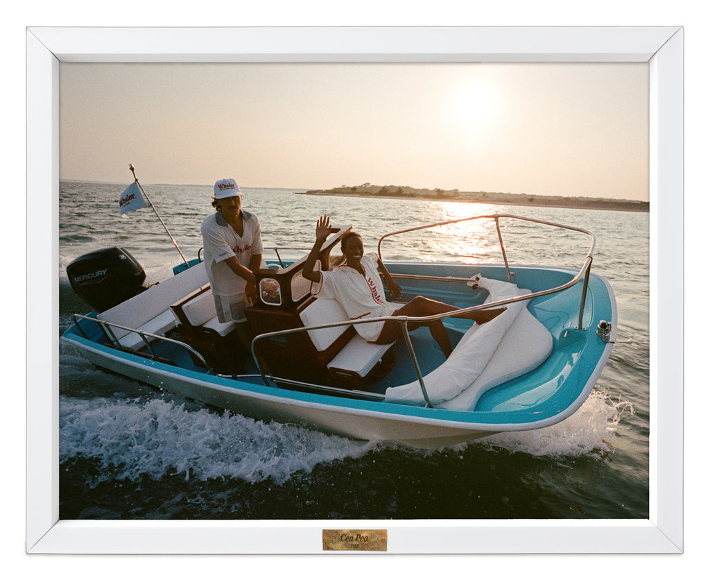 Two people on a boat in the water with a scenic background