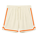 Beige shorts with white and orange varsity tape bordering the leg openings and sides of legs.