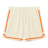 Beige shorts with white and orange varsity tape bordering the leg openings and sides of legs.
