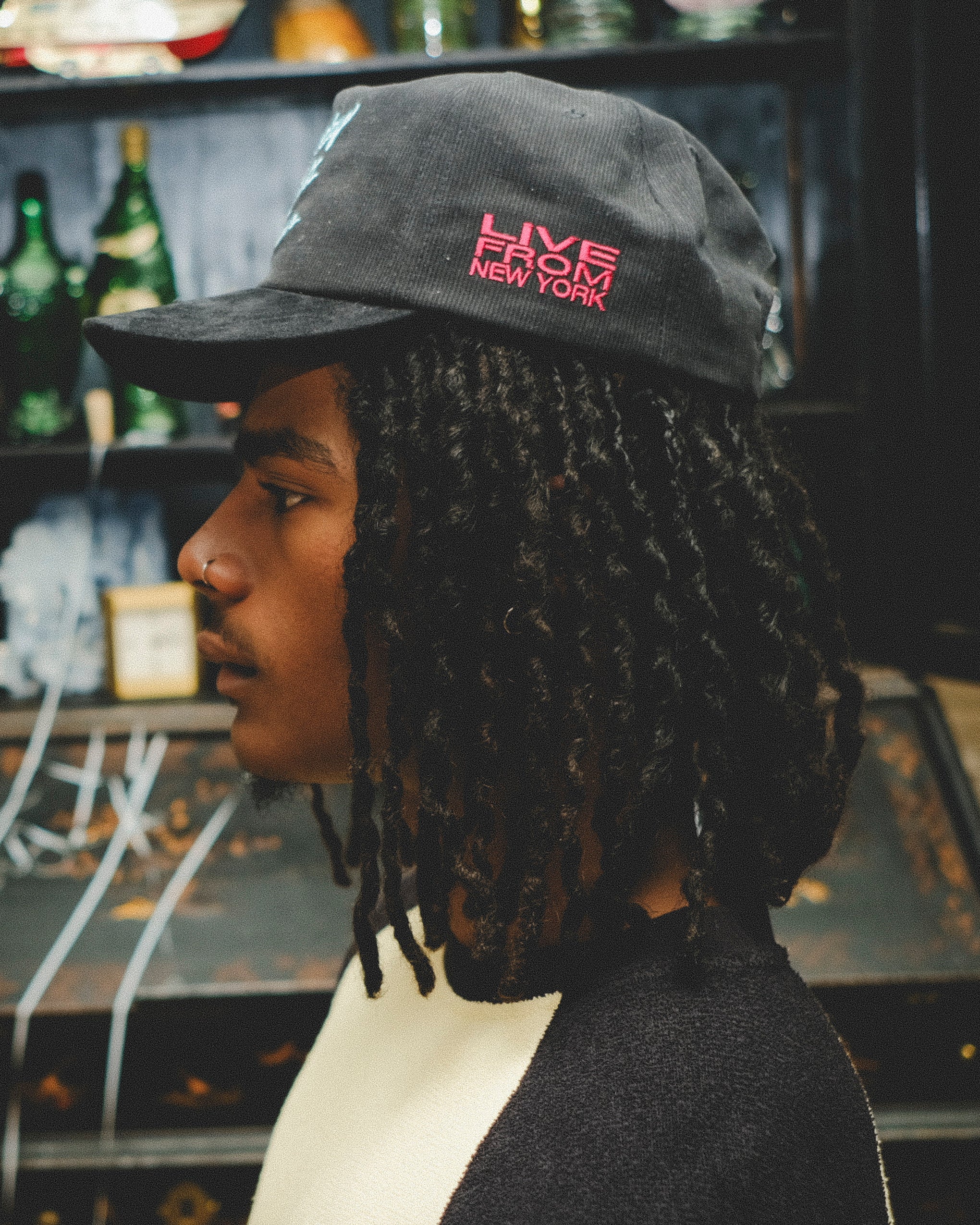 Man wearing a cap with 'Live from New York' text on the left temple.