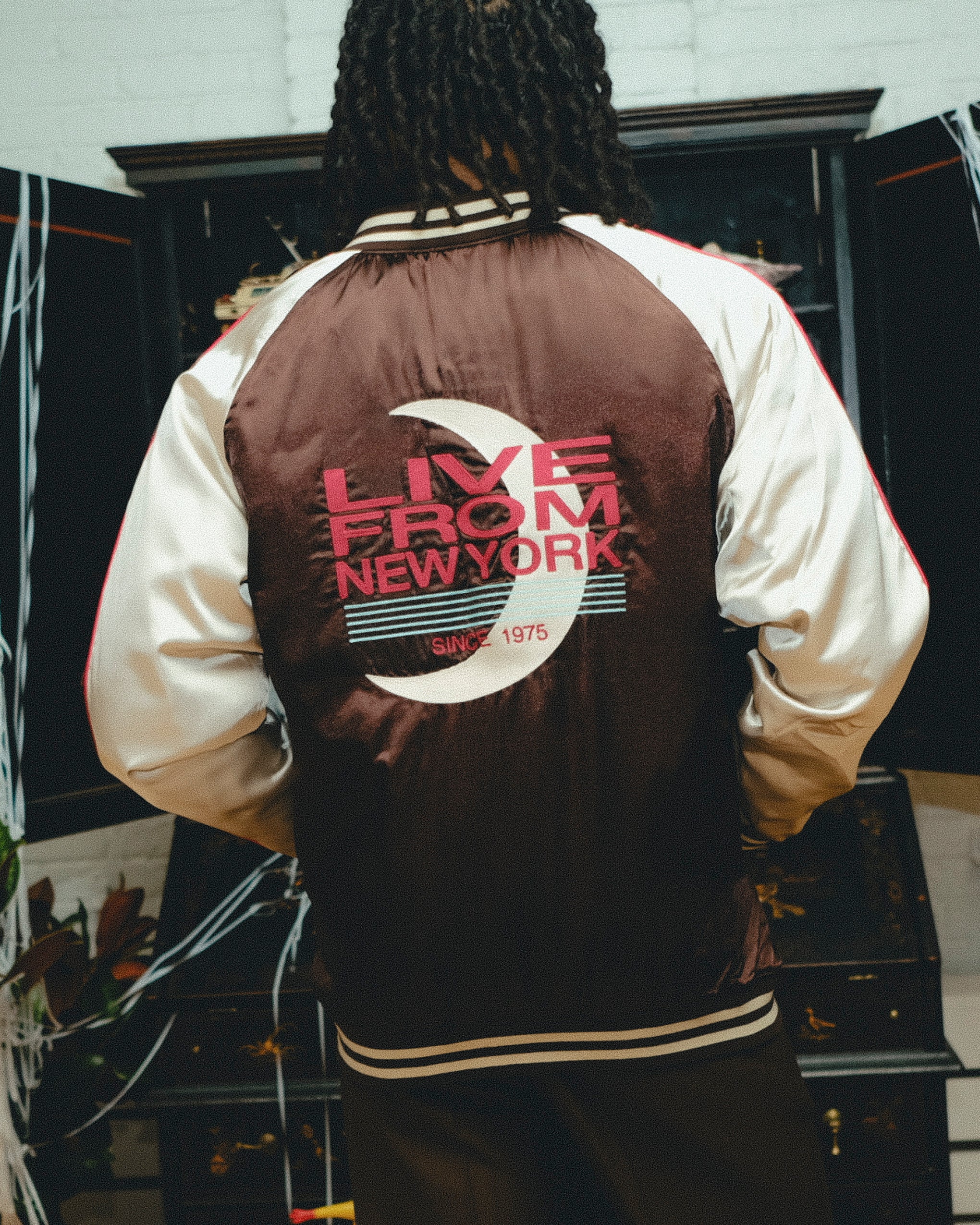 Back view of brown satin souvenir jacket with 'Live from New York' on back.