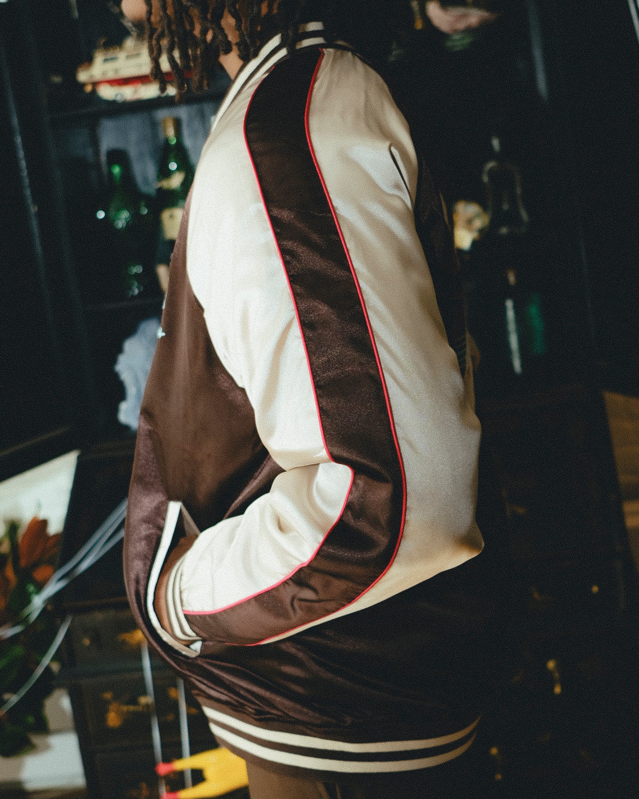 Brown and cream souvenir jacket with red trim on a dark background