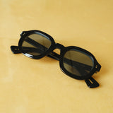 black thick sunglasses with blue frame against a yellow background