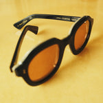 close up of black framed sunglasses with coral lenses that says 'LARGO LIMITED EDITION 113/210' in interior
