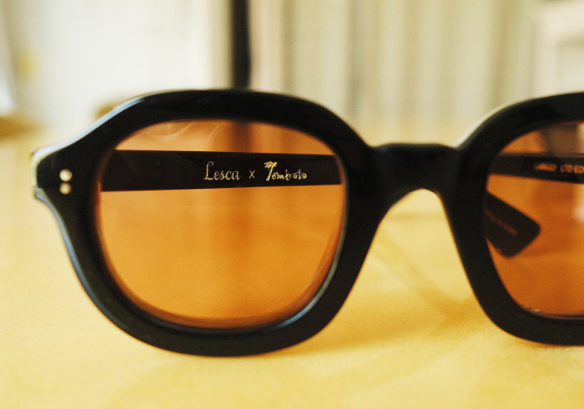 Lesca Lunetier X Tombolo lens in coral that showcases the ability to see the Lesca X Tombolo graphic on the frame through the coral lens.
