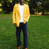 Man wearing the Easy Going Saffron Corduroy jacket with a pair of jeans, seen standing in the grass.