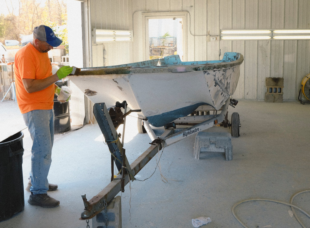 Person working on a boat inside a garage.