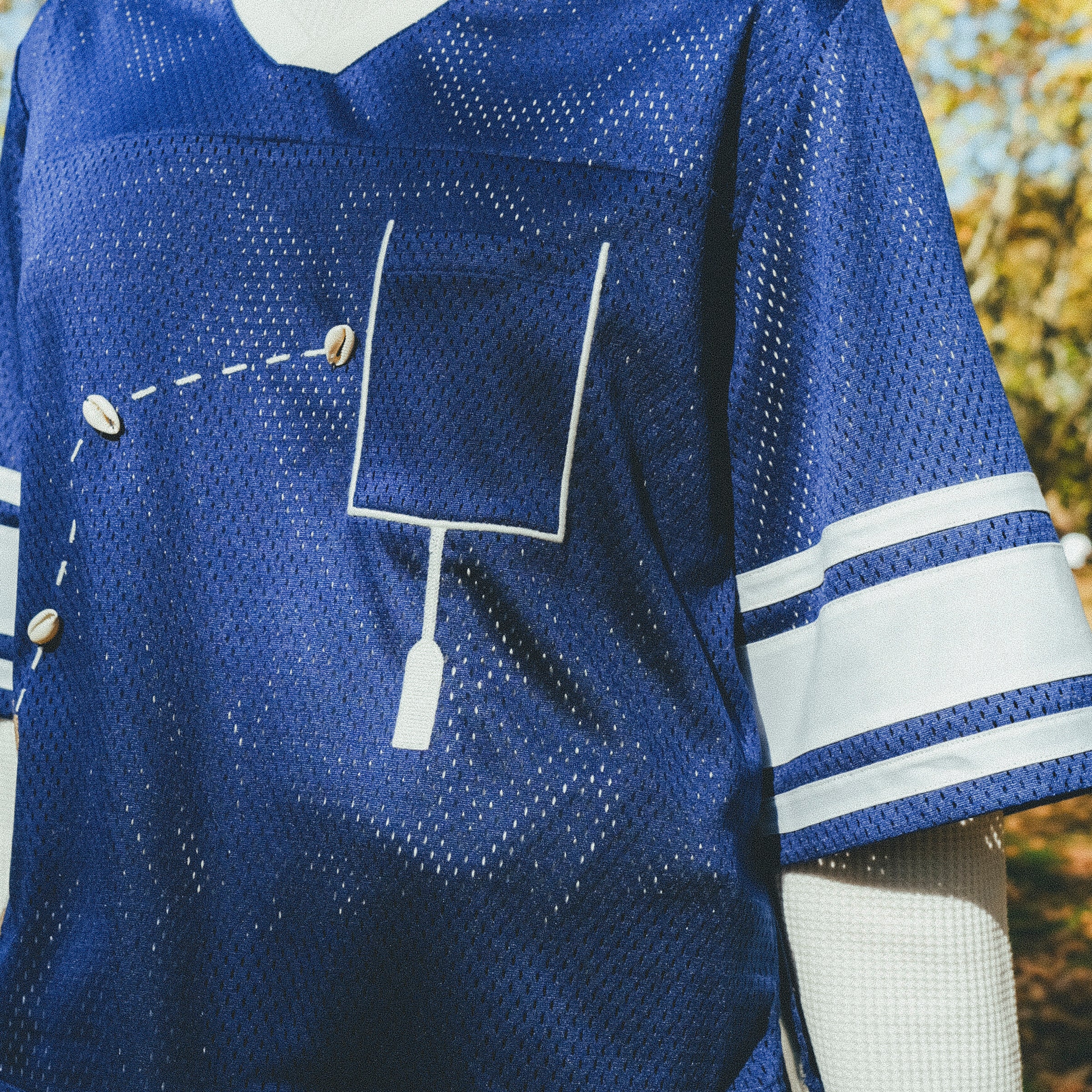 Close-up of a blue mesh jersey's front pocket.