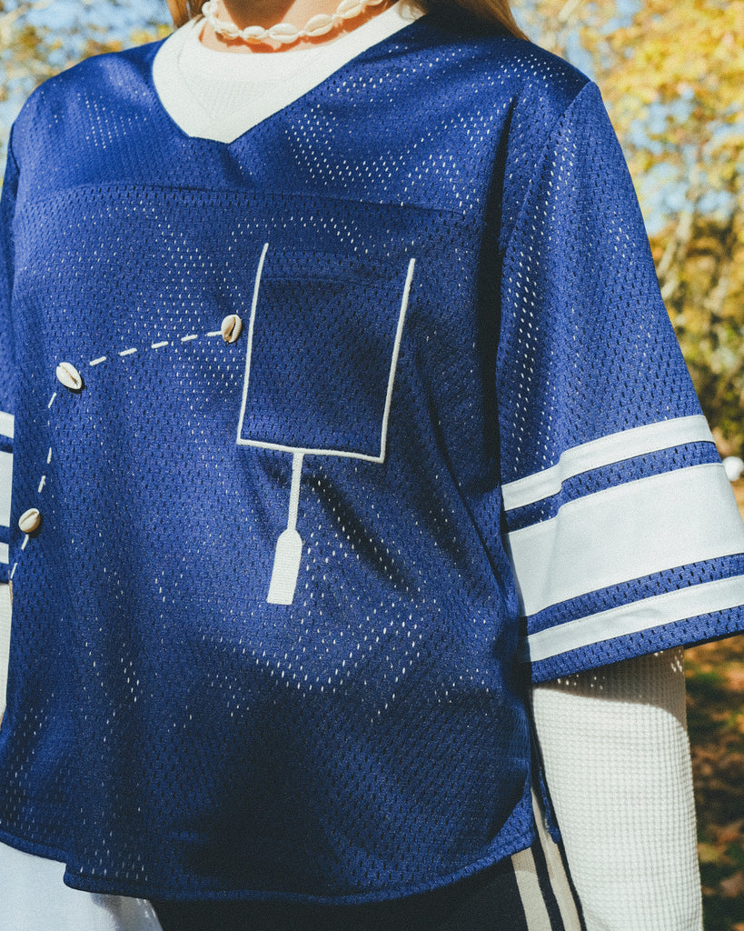 Close-up of a blue mesh jersey's front pocket.