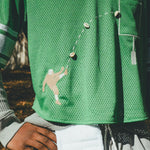 Close-up of embroidered football player kicking a football.