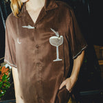 Woman posing in our brown Espresso Martini shirt, looking off to the side.