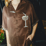 Woman posing in our brown Espresso Martini shirt, looking off to the side.