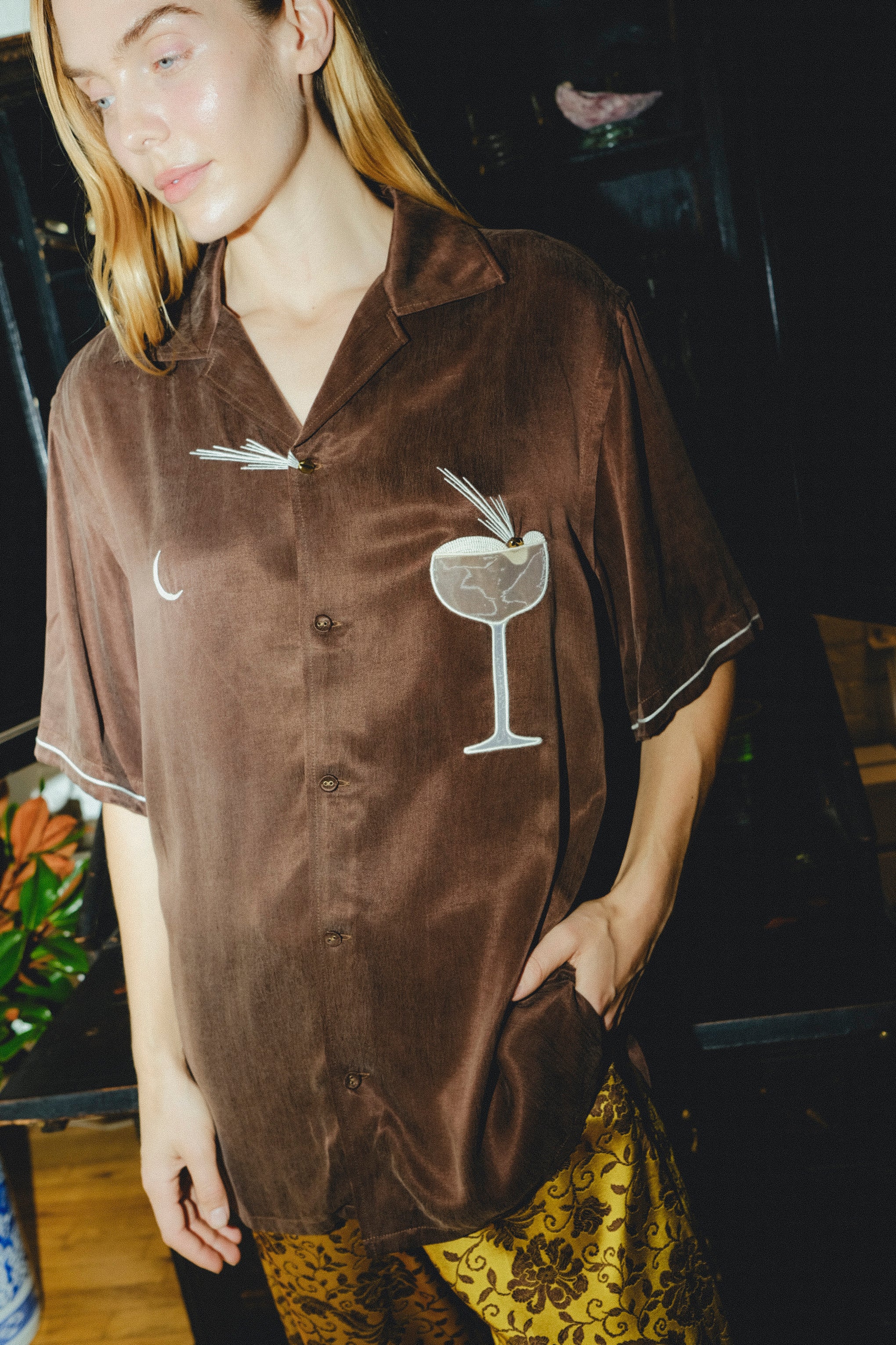 Woman posing in our brown Espresso Martini shirt, looking off to the side.