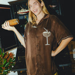 Woman wearing brown Espresso Martini cabana while holding a shaker.