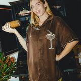 Woman wearing brown Espresso Martini cabana while holding a shaker.