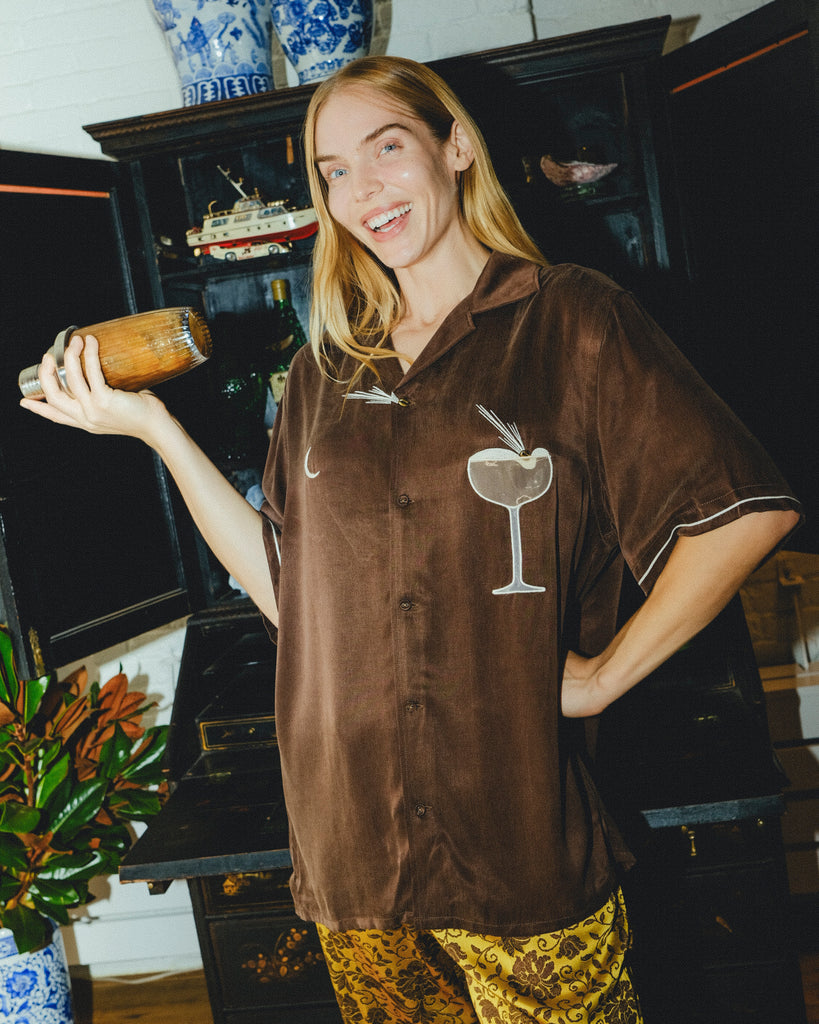 Woman wearing brown Espresso Martini cabana while holding a shaker.