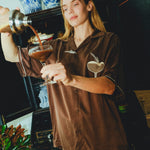 Woman in our espresso martini shirt is pouring her drink into a glass. 