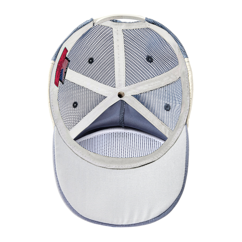 Inside view of a blue mesh hat showing white mesh panels, reinforced stitching, and a fabric sweatband. A red woven label with an American flag is sewn into the seam.