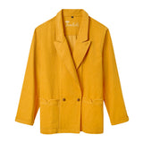A vibrant yellow corduroy jacket with a relaxed, double-breasted fit. It features two front buttons, wide notch lapels, and two large front patch pockets with flaps. The inside collar has “Tombolo” embroidered in cursive.