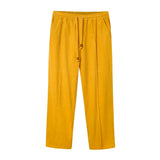 A pair of saffron yellow corduroy pants with an elasticized waist and drawstrings.