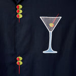 Detailed image of the embroidered olive skewers and the white mesh martini glass, over the wearer's left chest.