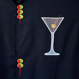Detailed image of the embroidered olive skewers and the white mesh martini glass, over the wearer's left chest.