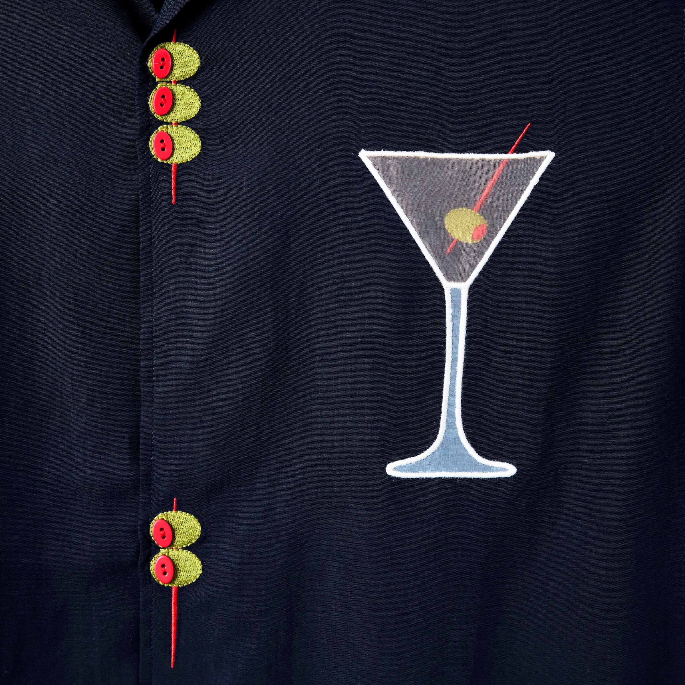 Detailed image of the embroidered olive skewers and the white mesh martini glass, over the wearer's left chest.