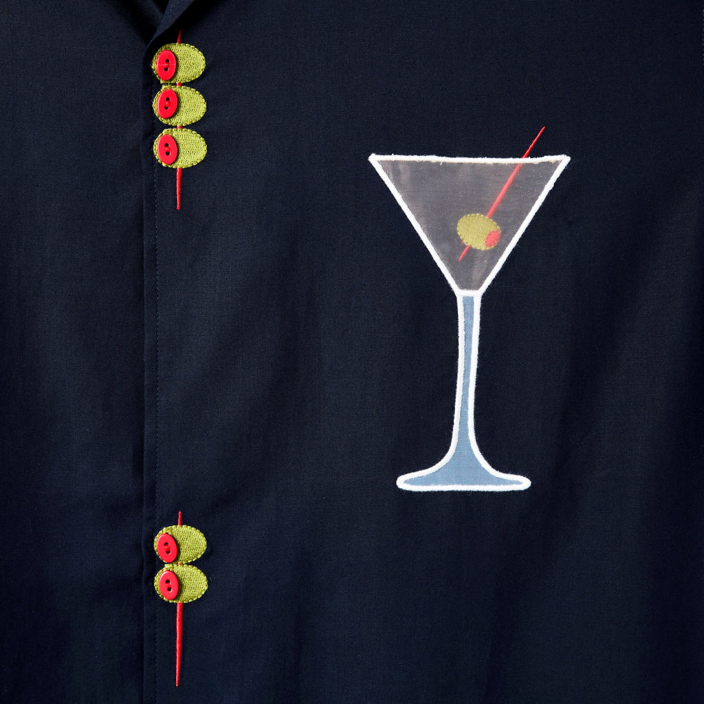 Detailed image of the embroidered olive skewers and the white mesh martini glass, over the wearer's left chest.