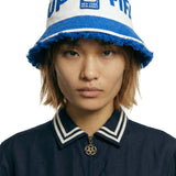 Person wearing a blue and white bucket hat with FIFA branding on a white background.