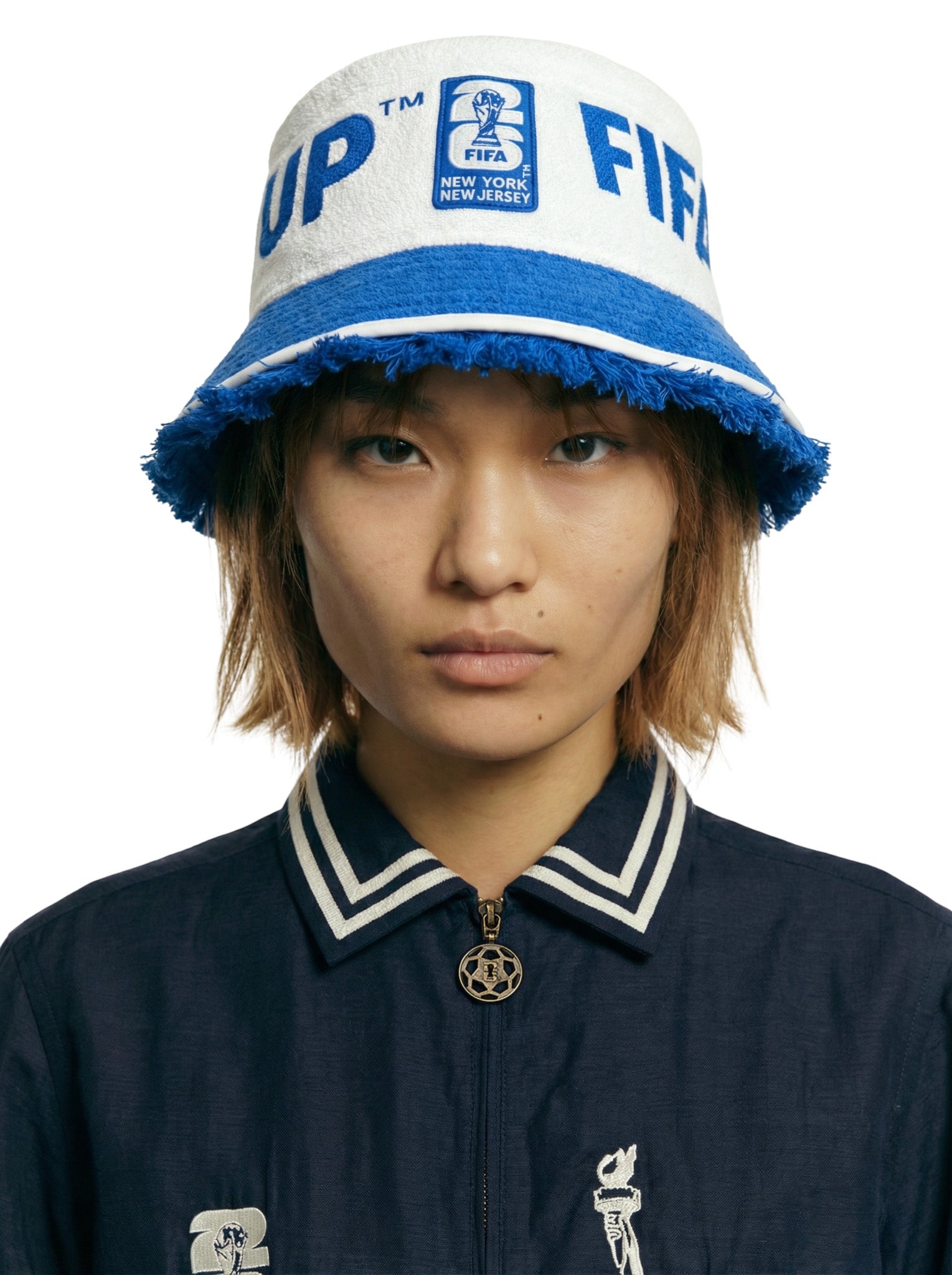 Person wearing a blue and white bucket hat with FIFA branding on a white background.