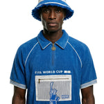 Person wearing a blue FIFA World Cup shirt and matching bucket hat on a white background.