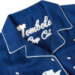 Close-up product image of the 'Teamwork' Cabana ~ Crop Cut's chain stitched interior label which reads: "Tombolo Crop Cut" in a cursive font.