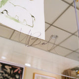 Zoomed-in image of the artist, Mary Ball's signature on the glass case.