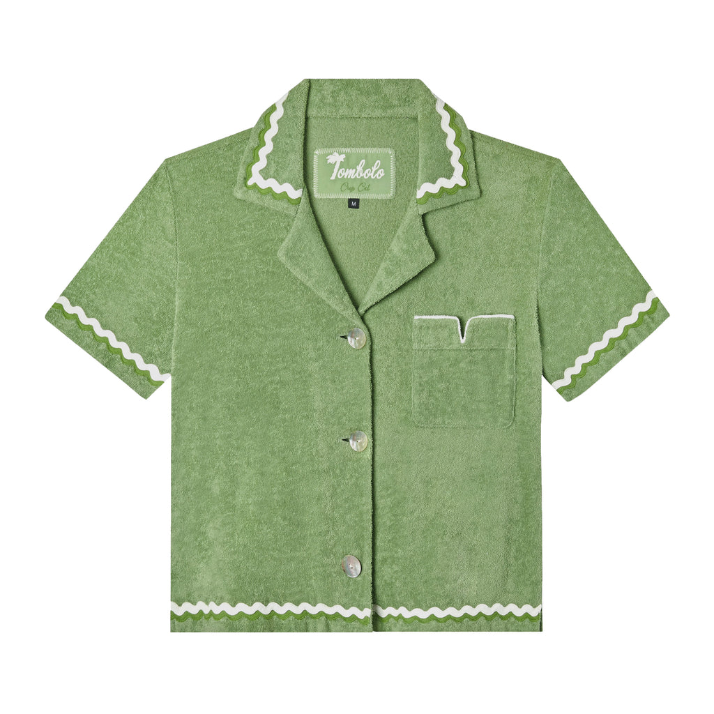 Front-facing product image of the 'Rick Rack' Cabana ~ Crop Cut (green) made of 100% Organic Cotton Terry Cloth that features oversized agoya shell buttons, signature Tombolo v-slit pocket on chest, overlapping rick rack embroidery on collar, cuffs, and bottom sweep, and a custom woven Tombolo label.