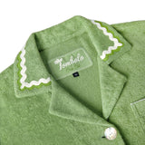 Close-up product image of the 'Rick Rack' Cabana ~ Crop Cut's (Green) custom interior woven label and oversized agoya shell buttons.