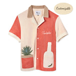 A short-sleeved '¡Gusanito!' Cabana shirt in beige and red, featuring embroidered agave and gusano designs, and a bottle-shaped pocket. Also includes 'Tombolo' embroidery on the chest.