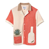Tombolo salmon and light pink cotton terry cloth shirt with a light pink tequila bottle with a green worm inside on the right and an agave plant in a salmon colored pot on the left side, has a beige collar and four white buttons