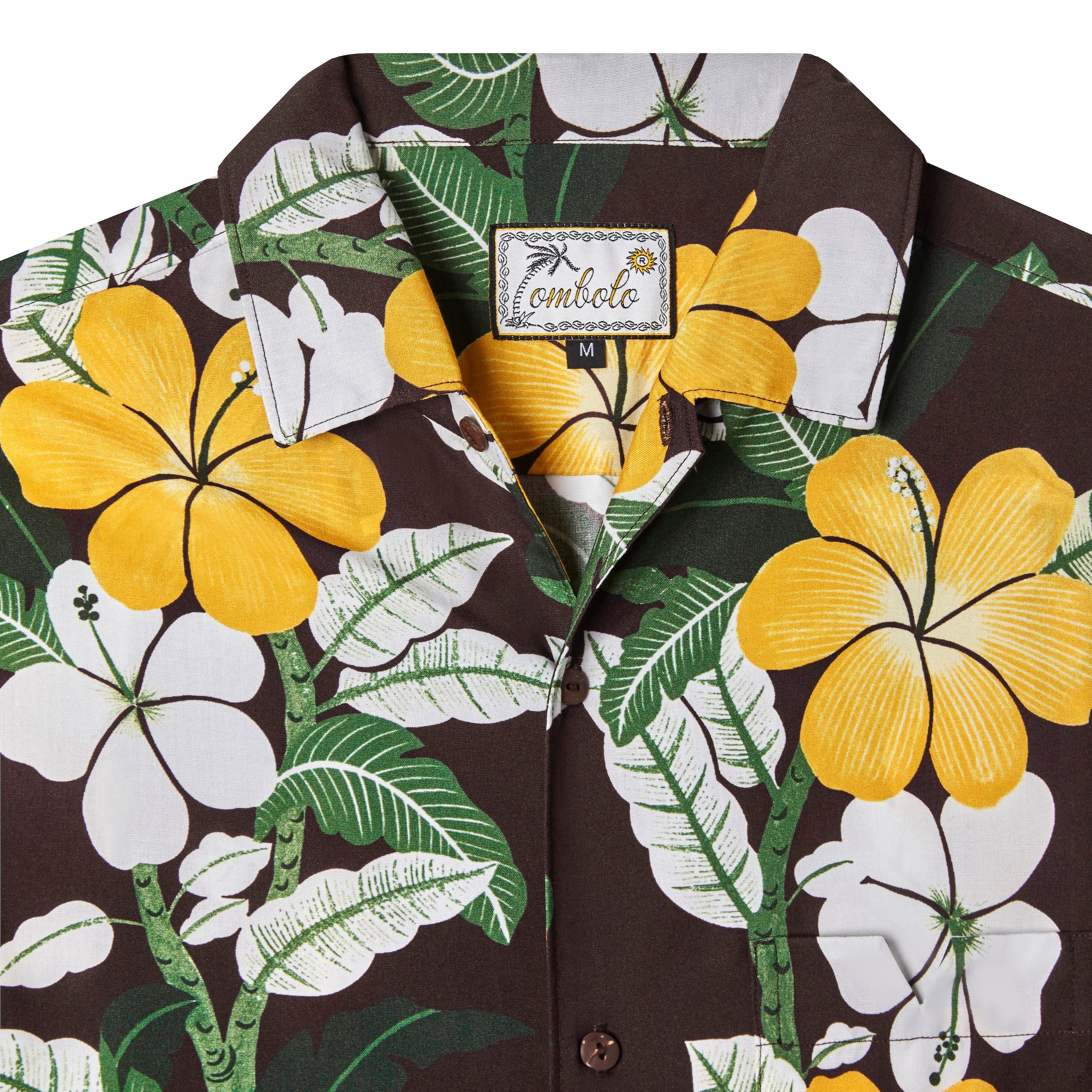 Close up front-facing product image of "Night Bloom" buttoned shirt with one button undone that emphasizes intricacies of hibiscus floral pattern that features yellow, green, and white accents on a brown base, in addition to the tag which shows a leaning palm tree as the "T" in Tombolo in a script font.