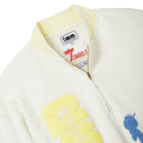 Close-up of a cream-colored jacket with embroidered designs and a visible brand label.