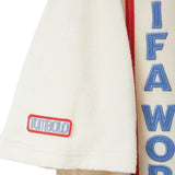 Close-up of beige terry cabana sleeve with Tombolo patch and red-trimmed FIFA WORLD CUP embroidery panel.
